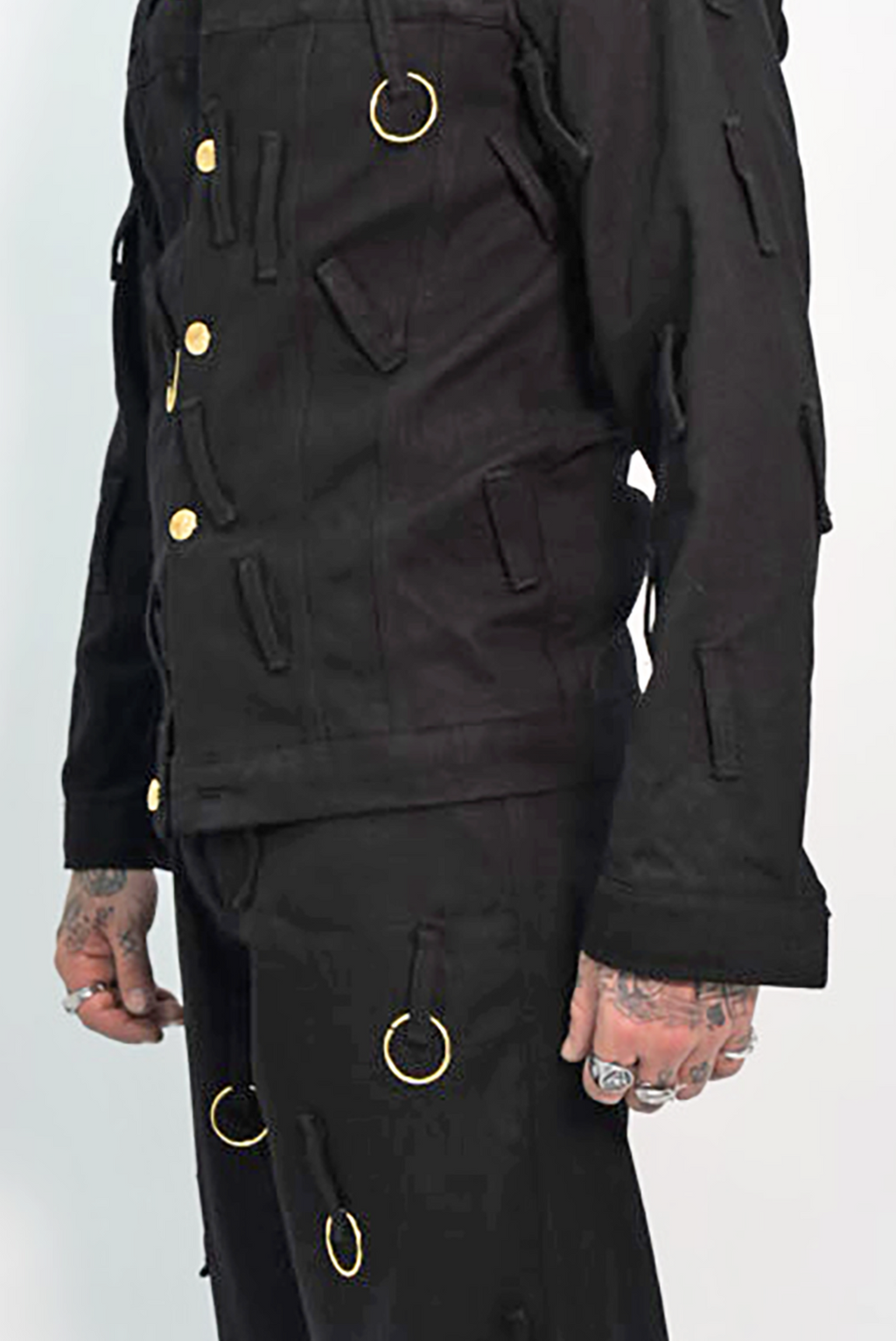 Man wearing a black outfit with gold buttons on a white background