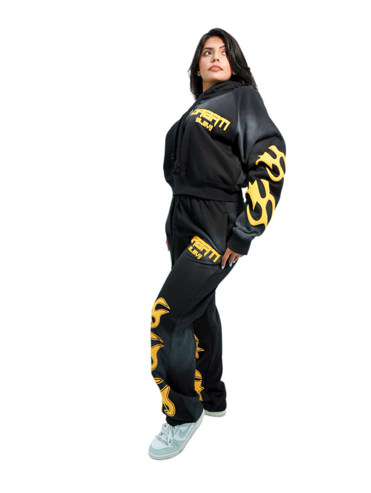 Person wearing a black tracksuit with yellow designs on a white background