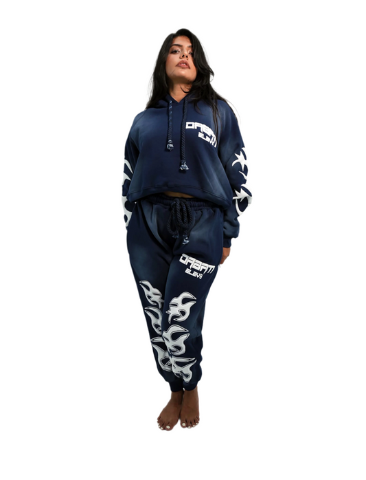 Person wearing a navy blue hoodie and jogger set with white branding on a white background
