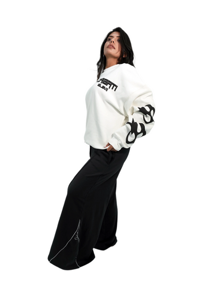 Person wearing a white sweatshirt with black text and graphics on a plain background