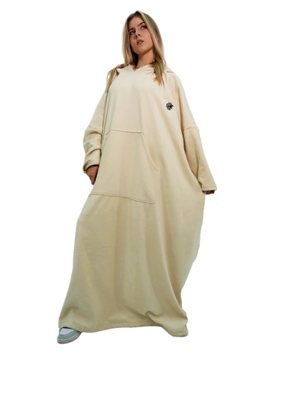 Woman wearing a beige outfit with a long dress and jacket on a white background