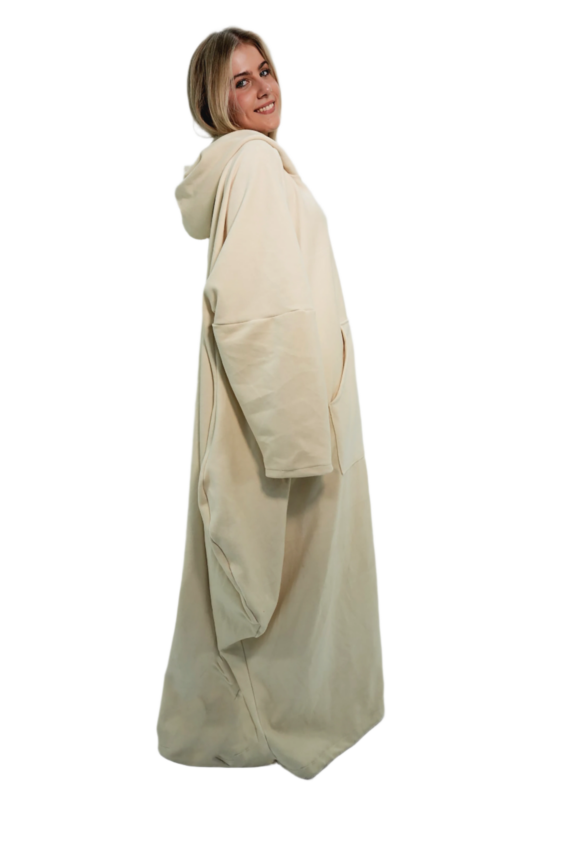 Person wearing a long beige coat against a plain background