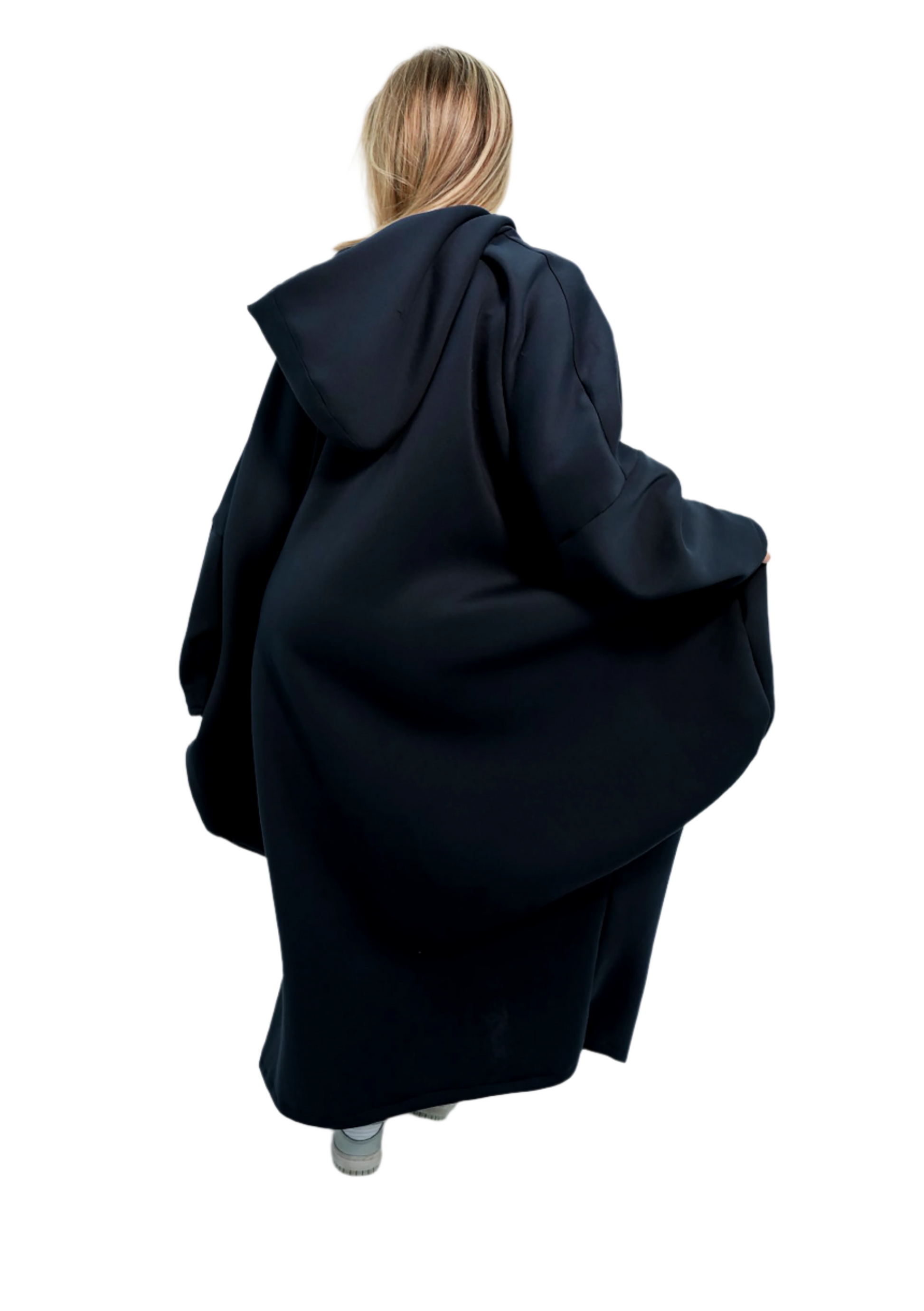 Person wearing a long black coat on a white background